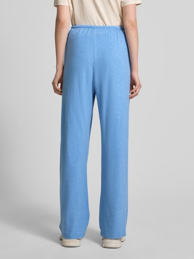 Frauenmodel trägt hellblaue Sweatpants mit elastischem Bund Modell 'YPAWOOD' von American Vintage im Loose Fit, Rückansicht Ganzkörperansicht.