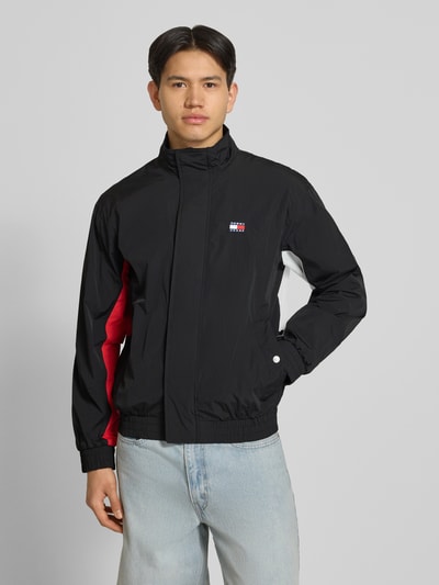 Männermodel trägt Regular Fit Blouson mit Logo-Stitching von Tommy Hilfiger, Optik: Unifarben, Materialverarbeitung: Satin, Ganzkörperansicht von vorne.
