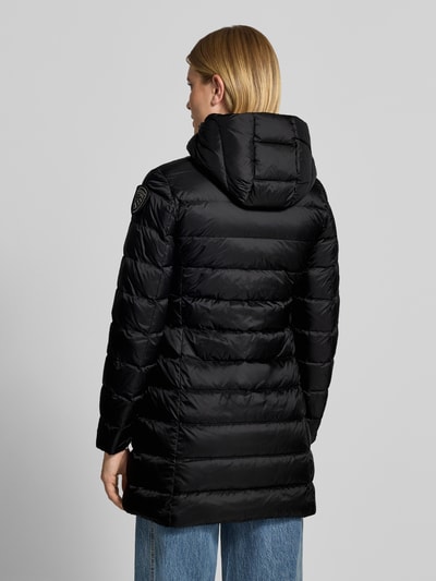 Frauenmodel trägt Mantel in Stepp-Optik Modell 'Agnes' von Blauer USA in Schwarz mit Kapuze und Logo-Detail, Ganzkörperansicht Rückansicht.