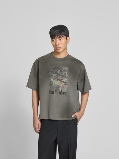 Männermodel trägt Relaxed Fit T-Shirt mit Foto-Print von WON HUNDRED aus reiner Baumwolle, Logo-Print, Rundhalsausschnitt, dunkle Farben, Ganzkörperansicht von vorne.