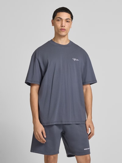 Męski model nosi Oversized Fit T-Shirt mit Logo-Stitching von Pegador, bawełna, krój oversized, wyhaftowane logo, okrągły dekolt, długość tyłu 71 cm w rozmiarze m, całkowity widok z przodu.