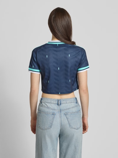 Frauenmodel trägt DFB Cropped Auswärtstrikot 2026 von adidas Sportswear, Mehrfarbig, Regular-Fit, Cropped, V-Ausschnitt, Applikation; Ganzkörperansicht Rückansicht.