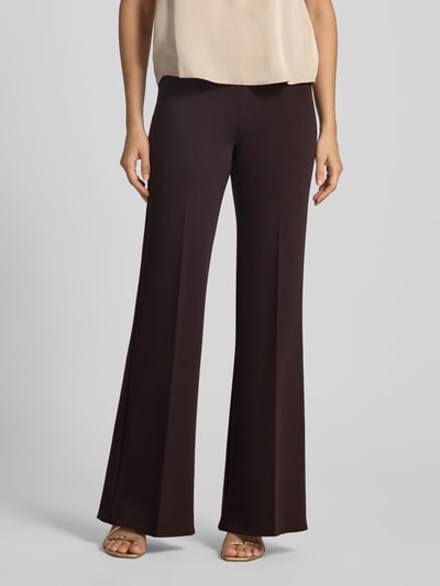 Frauenmodel trägt Flared Fit Stoffhose mit Bügelfalten von Rinascimento in Dunkelbraun, glatte Textur, elastischer Bund, Nahaufnahme Oberkörper, Material-Mix mit Stretch-Anteil, Bundweite 38 cm, Innenbeinlänge 85 cm.