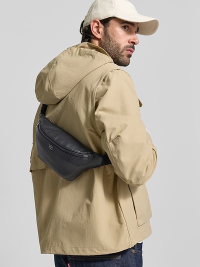 Männermodel trägt Bauchtasche mit Label-Applikation Modell 'QUANTIC' von HUGO aus genarbtem Leder, unifarben, Ganzkörperansicht Rückansicht