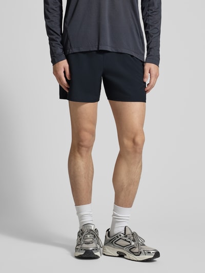 Männermodel trägt Shorts mit elastischem Bund und Tunnelzug von Salomon in Schwarz, Regular Fit, Logo, Ganzkörperansicht von vorne.