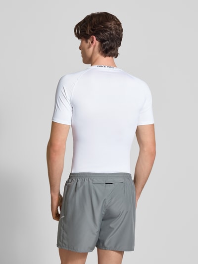 Männermodel trägt T-Shirt mit Logo-Print und Rundhalsausschnitt von NIKE TRAINING in Slim-Fit mit Raglanärmel, Rückenlänge 72 cm, Ganzkörperansicht Rückansicht.
