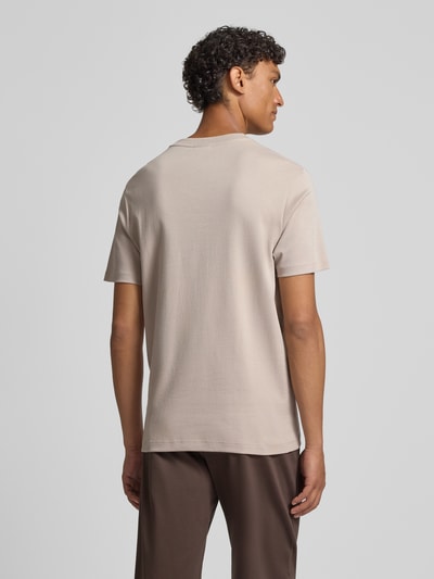 Męski model nosi T-Shirt mit Logo-Stitching Modell 'Priamo' od JOOP! Collection, beżowy kolor, czysta bawełna, prosty krój, tylny widok całej sylwetki.