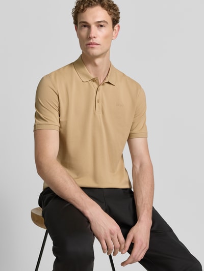 Mannelijk model draagt regular fit poloshirt van puur katoen model 'DONOS222' van HUGO in beige, heren poloshirt, close-up bovenlichaam