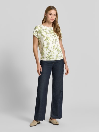 Frauenmodel trägt Relaxed Fit T-Shirt aus weichem Viskose-Mix von s.Oliver RED LABEL, Optik:Allover-Muster, Florales-Muster, U-Boot-Ausschnitt, Kurzarm, Material: Viskose-Mix, helle Töne und grüne Muster, Ganzkörperansicht von vorne.