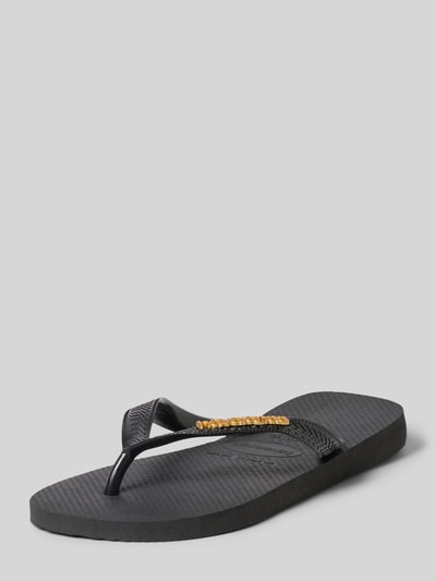 Produktfoto, Zehentrenner mit Label-Detail von Havaianas, czarny kolor, płaska podeszwa, złoty detal, wysokość obcasa 1 cm w rozmiarze 39/40