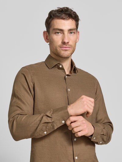 Männermodel trägt Regular Fit Leinenhemd mit Kentkragen von Christian Berg Men in Braun mit Knopfleiste, Nahaufnahme Oberkörper.