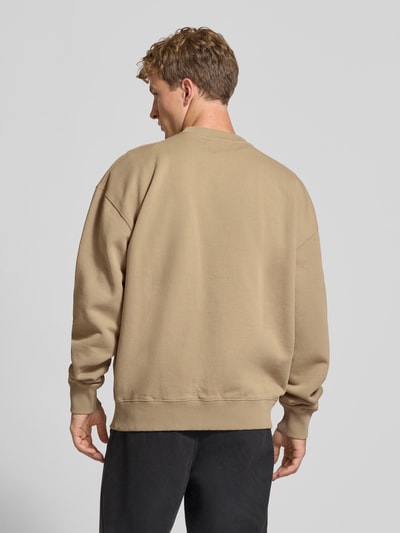 Männermodel trägt Relaxed Fit Sweatshirt aus Baumwoll-Mix von PEGADOR in Beige mit überschnittenen Schultern, Rückansicht, Ganzkörperansicht.