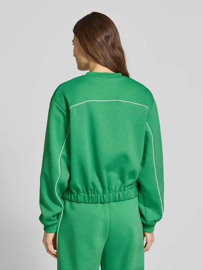 Frauenmodel trägt Regular Fit Jacke mit Viskose-Anteil Modell 'Kate' von ICHI in kräftigem Grün, elastischer Material-Mix, Stehkragen, Pattentaschen, durchgängige Knopfleiste, elastische Ärmelabschlüsse, Rückenlänge 53 cm, Schulterbreite 44 cm, Brustweite 60 cm, Ärmellänge 62 cm, Ganzkörperansicht Rückansicht.
