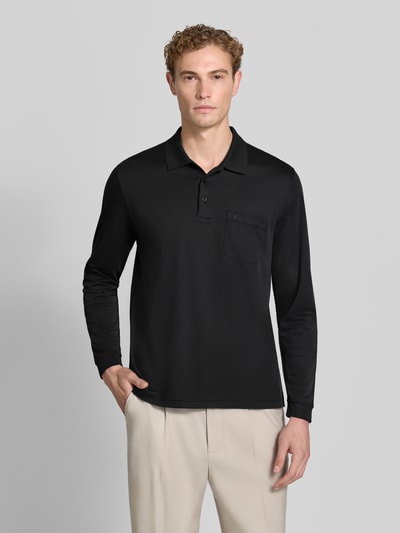 Männermodel trägt Regular Fit Poloshirt aus Baumwoll-Mix von RAGMAN in Schwarz mit Brusttasche, elastische Abschlüsse, Ganzkörperansicht von vorne. Herren Poloshirt, langärmelig, Rückenlänge bei Größe M 70 cm.