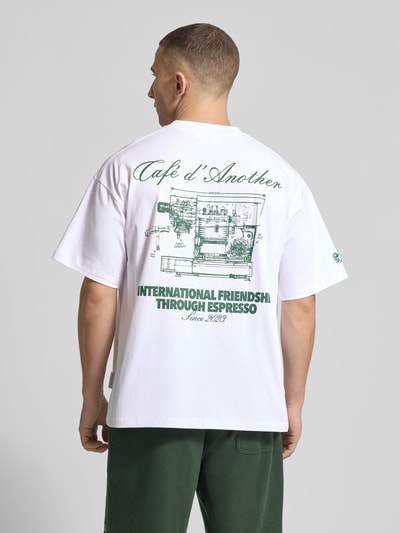 Männermodel trägt Regular Fit T-Shirt mit Logo-Print von ANOTHER COTTON LAB, Baumwoll-Mix, weiß mit grünem Print, Ganzkörperansicht Rückansicht.