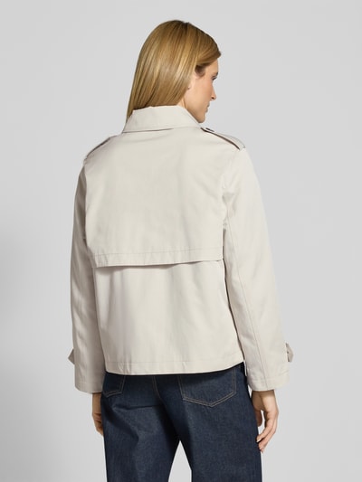Frauenmodel trägt Trenchcoat in kurzem Design mit Baumwoll-Anteil von Jake*s Casual in Beige, strukturierte Optik, Ganzkörperansicht Rückansicht.