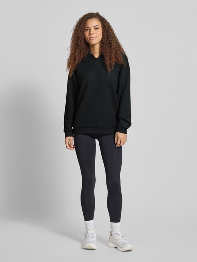 Frauenmodel trägt Relaxed Fit Poloshirt mit Lyocell-Anteil von PUMA, elastischer Material-Mix, Langärmelig, Logo-Detail, Polo-Kragen, unifarben, Ganzkörperansicht von vorne.