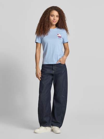 Frauenmodel trägt Damen T-Shirt von Only, Modell 'KITA', Optik: Unifarben, Passform: Shaped Fit, Motiv-Print, Pailletten, Strasssteine, Rundhals, Kurzarm, Materialverarbeitung: Jersey, Reine Baumwolle, hellblau, glatte Textur, Ganzkörperansicht von vorne.