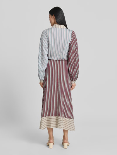 Kobiece modelka nosi sukienkę koszulową 'Hemdblusenkleid aus Lyocell-Mix mit Bindegürtel' od Jake*s Casual, mieszanka lyocellu z dodatkiem wiskozy, linia a, sukienka midi, wzór na całej powierzchni, zakryta listwa guzikowa, wiązany pasek, długość tyłu w rozmiarze 36: 124 cm, szerokość w rozmiarze 36: 41 cm, długość rękawów w rozmiarze 36: 57 cm, kolory: błękit, brąz, beż, tkanina z wyraźną strukturą, widoczny kontrast pasów, całkowity widok od tyłu.