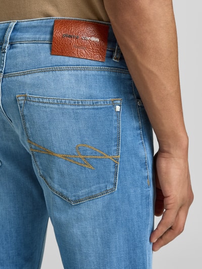 Männermodel trägt Jeans aus Candiani Denim Modell 'Lyon' von Pierre Cardin, blauw, tapered fit, katoenmix met stretch, detailopname heup.