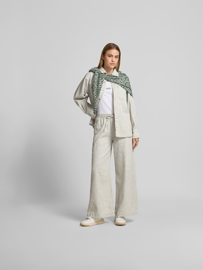 Frauenmodel trägt Stoffhose mit Allover-Animal-Print von Lala Berlin aus reiner Baumwolle, Wide-Fit, Eingriff- und Gesäßtaschen, Ganzkörperansicht von vorne.
