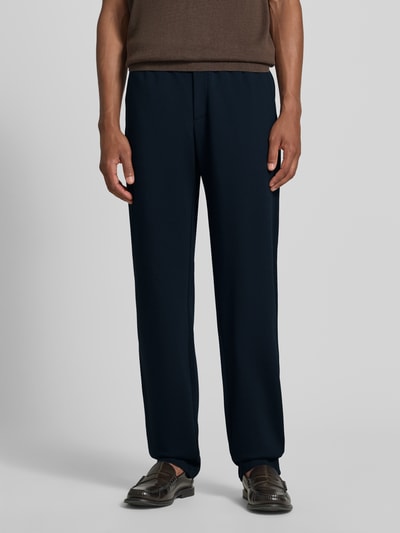 Männermodel trägt Chino mit Gesäßleistentaschen und Eingrifftaschen von Emporio Armani in Dunkelblau, Straight Fit, Ganzkörperansicht von vorne. Baumwoll-Mix mit Lanawolle-Anteil, Knopf- und Reißverschluss, Bundweite 42 cm, Innenbeinlänge 86 cm.