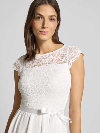 Frauenmodel trägt Cocktailkleid mit Spitzenbesatz und Bindegürtel von SWING in Weiß, Material-Mix mit Stretch-Anteil, Nahaufnahme Oberkörper.