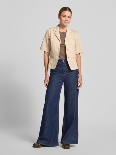 Frauenmodel trägt Blazer mit Viskose-Anteil Modell 'Kate' von ICHI in Beige mit Reverskragen, Halbarm, Knopfleiste, Paspeltaschen, Tailliert, Elastischer-Material-Mix, Ganzkörperansicht von vorne.