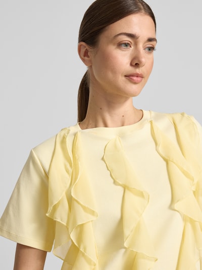 Vrouwenmodel draagt T-Shirt met Rüschen und Rundhalsausschnitt van Christian Berg Woman, rechte fit in geel, pure katoen, detailopname bovenlichaam.