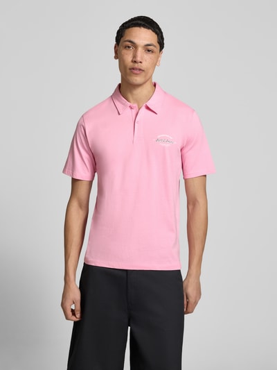 Männermodel trägt Poloshirt mit Label-Print Modell 'BRANDON' von Jack & Jones aus reiner Baumwolle, Regular-Fit, Polokragen, kurze Knopfleiste, Rückenlänge bei Größe M 71 cm, Ganzkörperansicht von vorne.