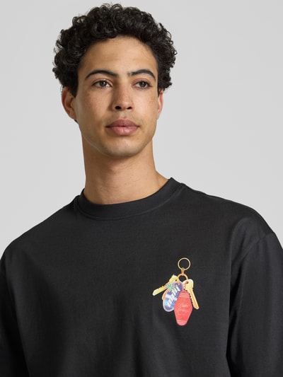 Männermodel trägt Boxy Fit T-Shirt aus reiner Baumwolle Modell 'FRED ESCAPE' von Only & Sons, unifarben, Motiv-Print, Jersey, Nahaufnahme Oberkörper.