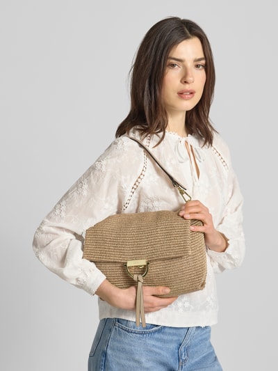 Frauenmodel trägt Handtasche mit Logo-Detail Modell 'Temi' von Abro in Flecht-Optik, beige, abnehmbarer Schulterriemen, Nahaufnahme Oberkörper.