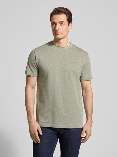 Męski model nosi T-shirt mit Rundhalsausschnitt und Label-Stitching od Gant, bawełna, krój regular fit, okrągły dekolt, długość tyłu w rozmiarze M: 69 cm, jasna zieleń, gładka faktura, całkowity widok z przodu.