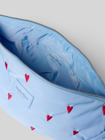 Produktfoto, hellblaue Handtasche mit roten Herzen, Stitchings, Hauptfach mit Reißverschluss, Modell 'Puffy Adult Fanny Pack' von STUDIO NOOS, glatte Textur, Maße: Breite 34 cm, Länge 21 cm, Tiefe 9 cm, Schulterriemen 71 cm.