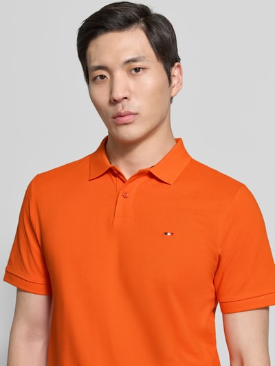 Männermodel trägt Regular Fit Poloshirt mit Logo-Stitching von HECHTER PARIS in Orange, Reine Baumwolle, Strukturmuster, Kurzärmelig, Polokragen, Nahaufnahme Oberkörper.