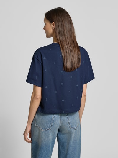 Frauenmodel trägt Oversized T-Shirt aus Baumwoll-Mix von Lacoste Sport in Dunkelblau, unifarben mit Tennis-Print und Logo-Patch, Ganzkörperansicht Rückansicht.