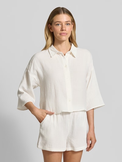 Frauenmodel trägt Loose Fit Hemdbluse aus reiner Baumwolle Modell 'NATALI' von Vero Moda, Optik: Unifarben, Materialverarbeitung: Seersucker, 3/4-Arm, Hemdkragen, einreihige Knopfleiste, Ganzkörperansicht von vorne.