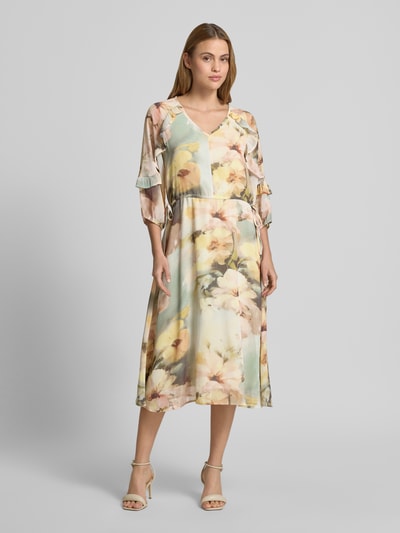 Frauenmodel trägt Midikleid mit V-Ausschnitt von Soyaconcept, florales Muster in Pastell, Rüschenbesatz, Midilänge, 3/4-Arm, Ganzkörperansicht von vorne. Rückenlänge bei Größe S: 128 cm, Brustweite 40 cm, Ärmellänge 42 cm, leicht taillierte Passform.