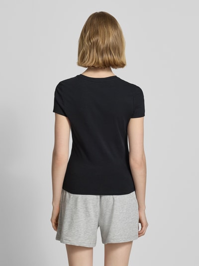 Frauenmodel trägt Slim Fit T-Shirt mit Motiv-Stitching von REVIEW in Schwarz, Damen T-Shirt aus Baumwoll-Mix, Rückenlänge 55 cm, Ganzkörperansicht Rückansicht.