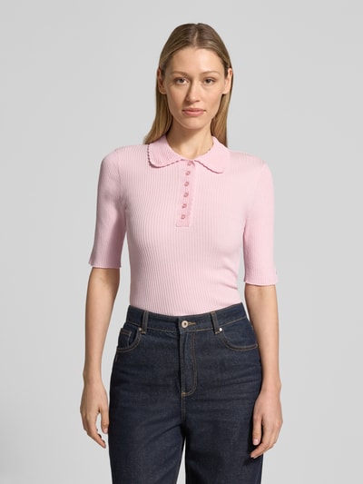 Modelka nosi Strickshirt mit 1/2-Arm und Polokragen von JAKE*S STUDIO WOMAN, różowy, dopasowany krój, mieszanka lyocellu, kołnierzyk polo, listwa guzikowa, drobne prążkowanie, rękaw o dł. 1/2, długość tyłu w rozmiarze S: 56 cm, długość rękawa: 28 cm, ujęcie całej sylwetki z przodu.