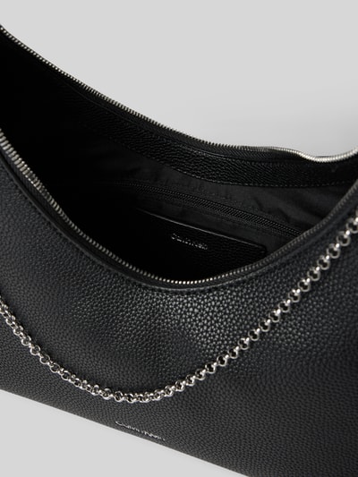 Produktfoto, Handtasche mit Label-Detail von CK Calvin Klein, czarna fakturowana powierzchnia, srebrny łańcuszek, kontekst: damska torebka, główna komora na zamek, label-detail, pasek na ramię, kieszeń wewnętrzna na zamek, szerokość w rozmiarze 1: 24 cm, długość w rozmiarze 1: 27 cm, głębokość w rozmiarze 1: 11 cm, długość paska na ramię w rozmiarze 1: 68 cm