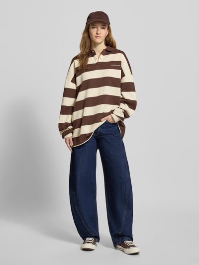 Vrouwenmodel draagt Loose Fit Jeans uit katoenmix van Tommy Jeans in denimlook, mid waist, 5-pocket, label patch, geheel vooraanzicht.