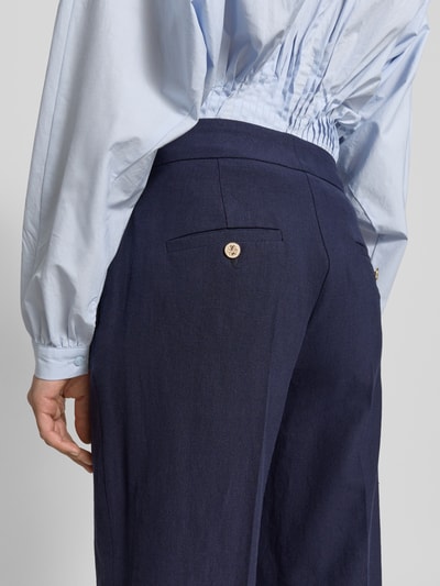 Vrouwenmodel draagt Straight Fit Leinenhose met viscose van SEDUCTIVE model 'Alara' met persplooien, klepzak, sierknopen, mix van linnen en viscose, achterzak, donkerblauw, detailopname achterkant.