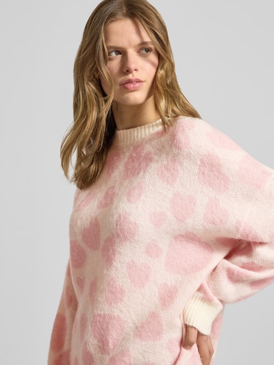 Frauenmodel trägt Relaxed-Fit Strickpullover mit Woll-Mohair-Anteil Modell 'Sallyna_B' von HUGO BLUE in Rosa mit Allover-Muster, Nahaufnahme Oberkörper.