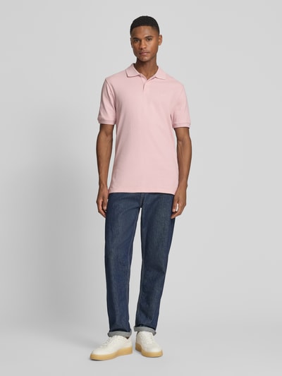 Männermodel trägt Slim Fit Poloshirt mit Label-Stitching von GAP aus Baumwoll-Elasthan-Mix, Ganzkörperansicht von vorne.