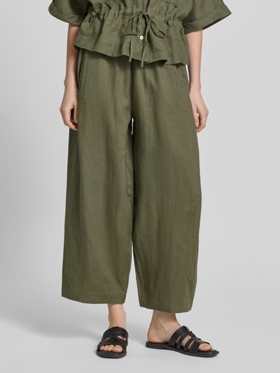 Modelka nosi Leinenhose in verkürzter Passform mit elastischem Bund von Christian Berg Woman, len, krój wide fit, kolor oliwkowy, tunel, szerokość w rozmiarze 36: 38 cm, długość wewnętrzna nogawki w rozmiarze 36: 64 cm, widok z przodu, całe ciało.