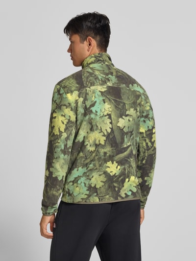 Mannenmodel draagt Regular fit sweatshirt Model 'NOVELTY' met camouflagemotief van The North Face, elastische boordjes, schipperstrui, ruglengte maat M 71 cm, mouwlengte maat M 69 cm, all-over groene, gele en bruine tinten, ganzicht rugaanzicht.