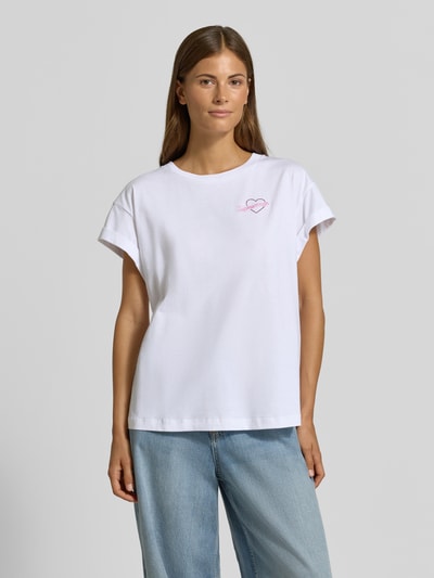 Frauenmodel trägt T-Shirt aus reiner Baumwolle von Rich & Royal in Weiß mit Statement-Stitching, lockerer Passform, Ganzkörperansicht von vorne.