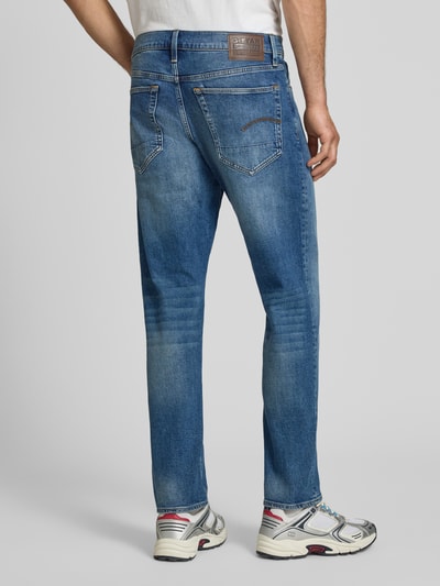 Männermodel trägt Regular Tapered Fit Jeans im Used Look Modell '3301' von G-Star Raw aus Baumwoll-Elasthan-Mix mit Eingrifftaschen, Ganzkörperansicht Rückansicht. Bundweite 43 cm, Innenbeinlänge 79 cm bei Größe 32/32.