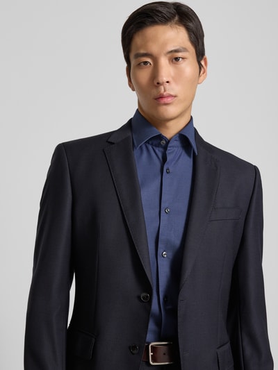 Männermodel trägt Slim Fit Businesshemd aus Baumwoll-Mix Modell 'HANK' von BOSS in Unifarben mit Struktur, Kentkragen, Nahaufnahme Oberkörper.